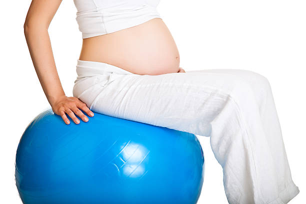 istock Pregnant woman excercises isolated on white 149147183