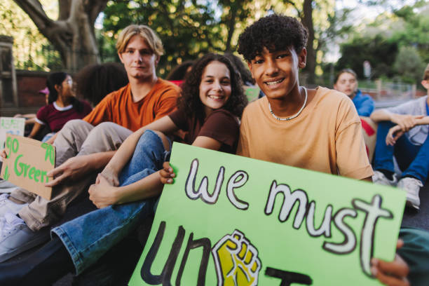 istock Diverse teenagers sitting at a climate change protest 1491473763