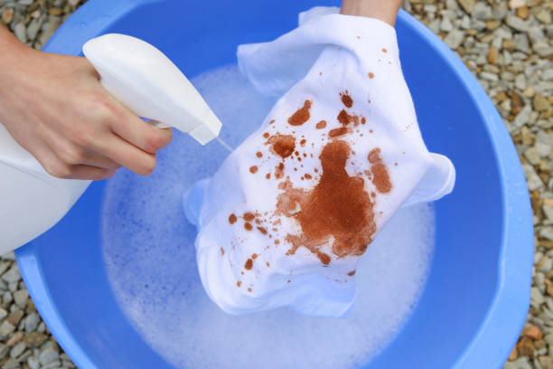 une femme essaie de laver une tache sur des vêtements blancs. - wash bowl photos et images de collection
