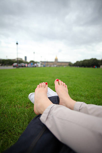 After many hours of walking across the streets of Paris two young people laid down on a public lawn to rest their tired feet