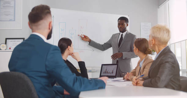 istock Cheerful african-american business coach explaining strategy to employees 1491478413