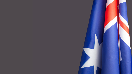 A Close-up of the Australian flag is on the right side on a gray background with copy space for text