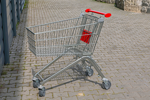 One Empty Shopping Cart at Pavement in Front of Store