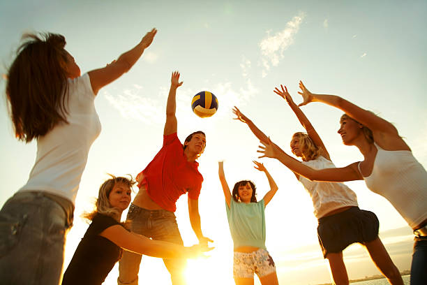 A group of people playing volleyball stock photo