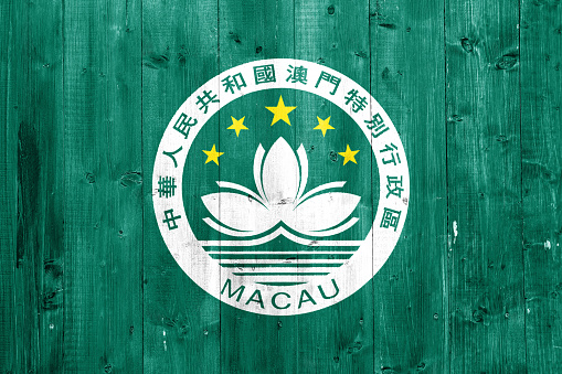 Macau flag on a textured background. Concept collage.