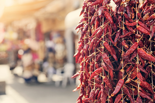 Dried Calabrian chili peppers hanging on street market\nCanon R5