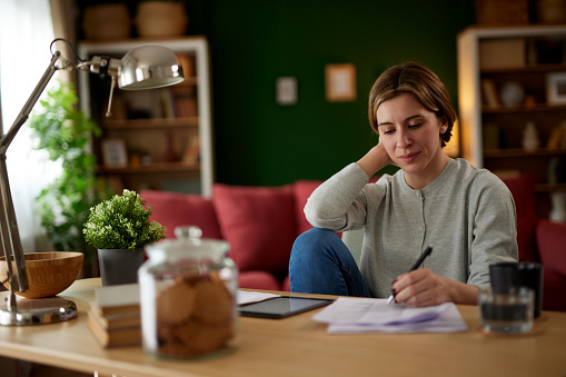 Women using digital tablet to check her finances at home office