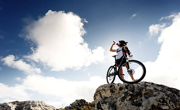 mountain bike drink Cyclist drinks water on top of a mountain with bike on a sunny day quench your thirst pictures stock pictures, royalty-free photos & images