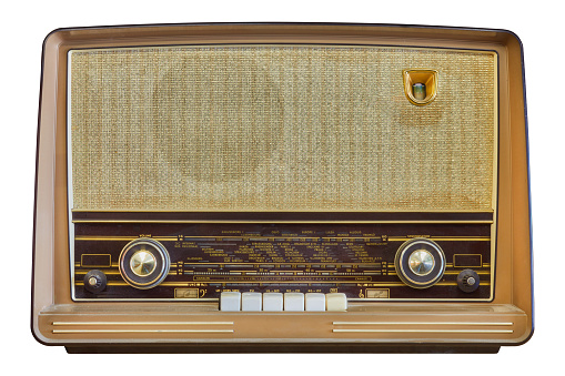 Closeup of vintage radio on wooden table with yellow wall