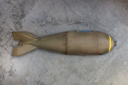 Ancient military missile bomb in front of an eroded grey background