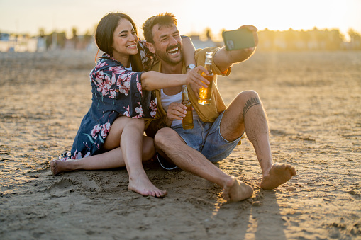 Loving young couple taking selfie at the beach