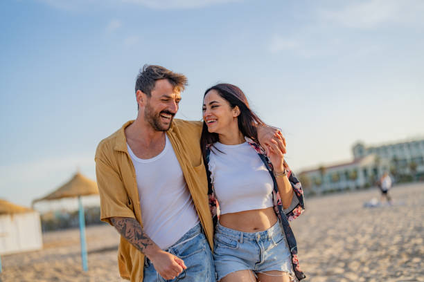 istock Young couple walking along a beach 1491495248