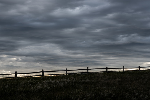 Split Rail Fence Silhouette With Gray Clouds Above