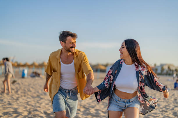 istock Young couple running on beach in spring day. 1491496127