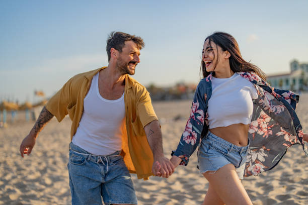 istock Happy couple having fun together running on beach 1491496242
