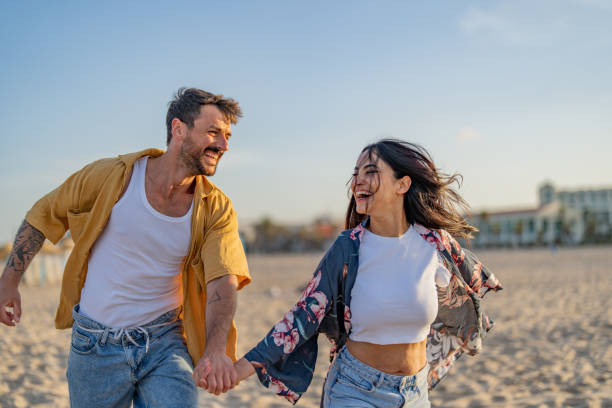 istock Couple running and playing on the beach at sunset or sunrise. 1491496269
