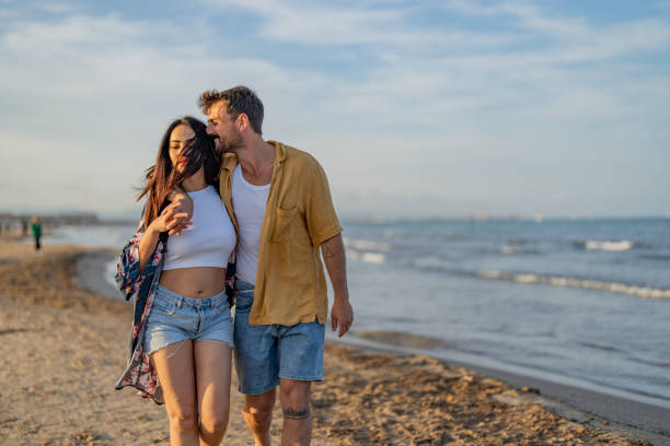 istock Couple Walking Holding Hands on Beach at Sunset 1491496673