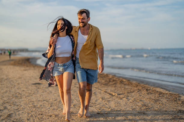 istock Couple Walking Along Beach Hand In Hand 1491496753