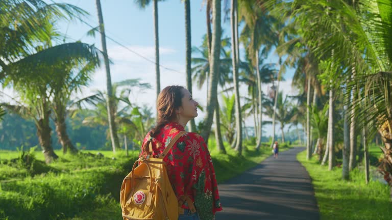 Woman walking in coconut tree grove on Bali