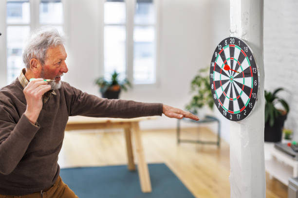 istock A cheerful senior is having a party and enjoying a dart game. 1491498038
