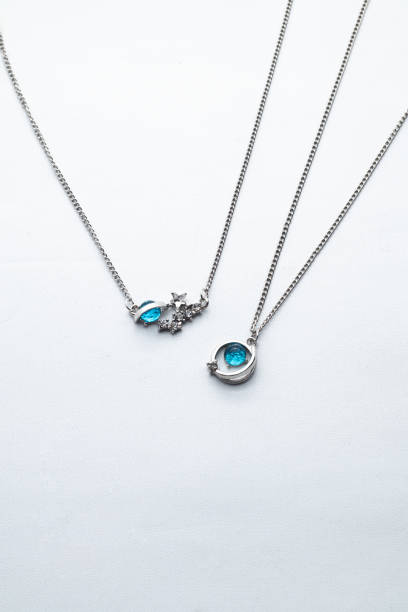 istock Silver chain necklace with blue diamond pendant on white background 1491498053