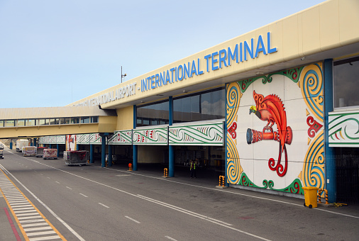 Port Moresby, Papua New Guinea: Port Moresby International Airport (IATA: POM, ICAO: AYPY), also known as Jacksons International Airport - air side façade of the international terminal with ULD cargo containers parked - decorated with the Raggiana Bird of Paradise, the national bird.