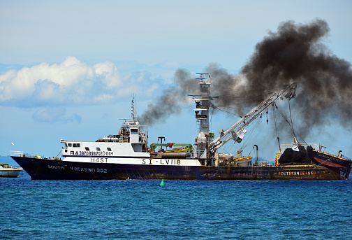 Honiara, Guadalcanal Island, Solomon Islands: Large fishing vessel and cloud of black smoke - Southern Seas Nº 302, registered in Honiara (IMO: 9764427, MMSI: 557005600). Originally built by Jinglu Shipbuilding for Taiwan Yuyou Fishery Co. Tuna trawler / seiner.