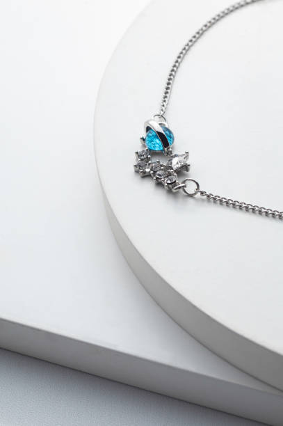 istock Silver chain necklace with blue diamond pendant on white background 1491502197