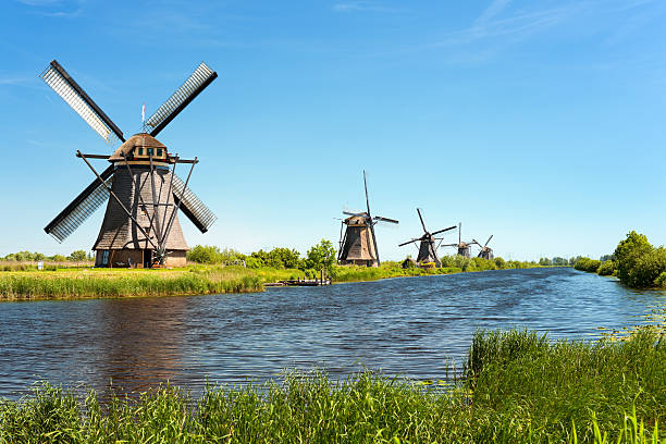Clear water in river running across windmills at Kinderdijk A windmills at Kinderdijk. GPS information is in the file watermill stock pictures, royalty-free photos & images