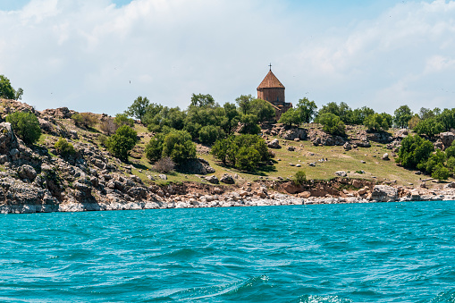 Akdamar Church, Aghtamar Church, Surp Haç Church or Holy Cross Cathedral is a church located on Akdamar Island on Lake Van, in eastern Turkey. It is surrounded by snowy mountains behind and almond trees around it.Seagulls are flying above it.Shot with a full-frame camera in daylight.