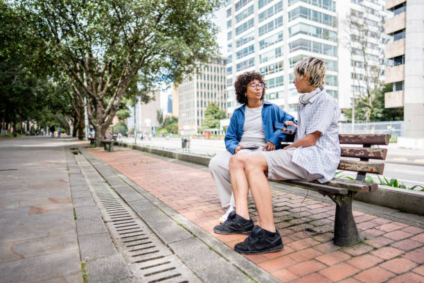 istock Young friends talking sitting on a bench outdoors 1491511500