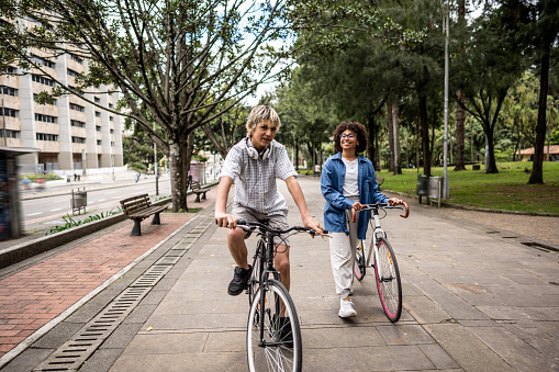 Young friends talking while riding bike outdoors