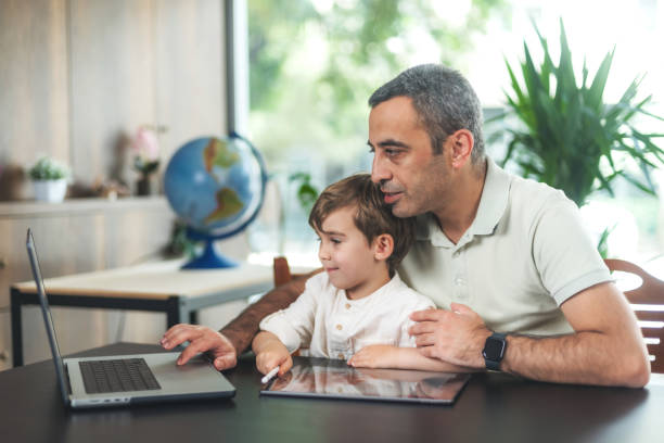 istock Father And Son Drawing Pictures On Digital Tablet 1491513089