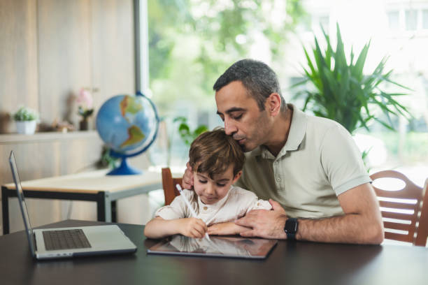 istock Father And Son Drawing Pictures On Digital Tablet 1491513330