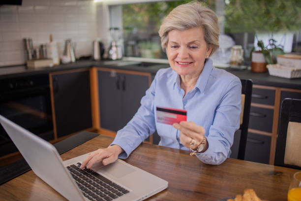 istock Happy senior customer enjoys shopping online 1491513491
