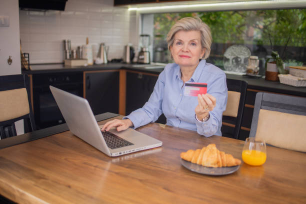 istock Happy senior customer enjoys shopping online 1491513514