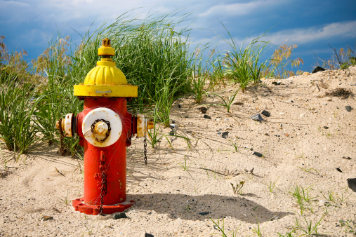 Fire hydrant on the beach with a stormy sky in the background