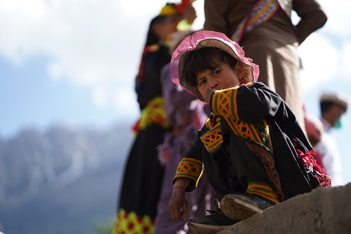 A Kalash child looking at the festivities of the Chilam Joshi Festival in Chitral\n\nDelve into the enchanting world of the Chilam Joshi Festival in Chitral as a Kalash child gazes wide-eyed at the mesmerizing festivities. Wrapped in vibrant traditional garments, the child's innocent curiosity captures the essence of this joyous celebration. Surrounded by music, dance, and colorful decorations, the festival comes alive, reflecting the rich cultural heritage of the Kalash community. Against the backdrop of the picturesque Chitral Valley, this captivating image encapsulates the spirit of cultural diversity and the significance of tradition. Immerse yourself in the wonder and excitement of the Chilam Joshi Festival through the eyes of this Kalash child, as they bear witness to the magic and splendor of their cultural roots.