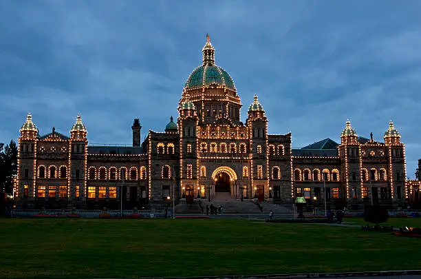 Canada, Victoria. Night falls over the illuminated Provincial House (Parliament) of British-Columbia. Deep blue skies over yellow lights lining dark bulding .