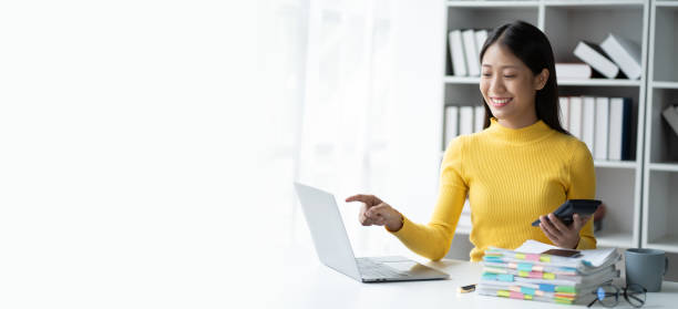 istock Young smart businesswoman pointing at laptop computer while holding her smartphone. 1491521488