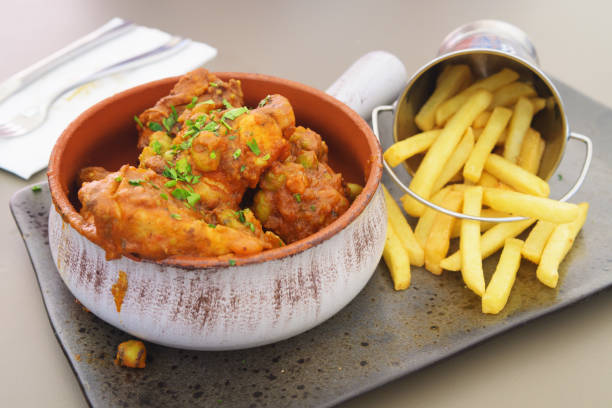 Tasty spicy rabbit stew in tomato sauce with French fries as a side dish stock photo