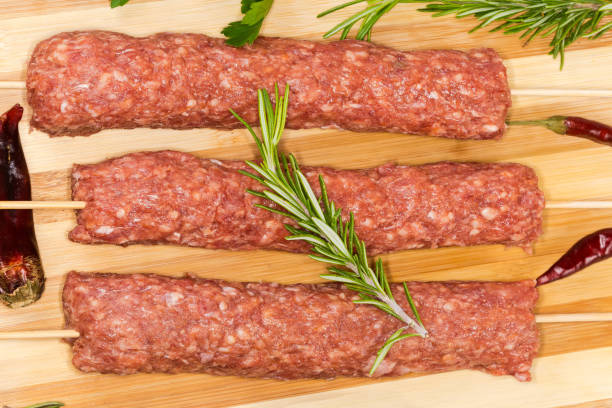 istock Raw lula kebab on cutting board among spices, top view 1491526898
