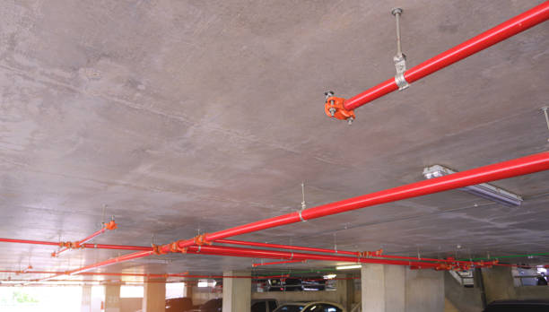 istock Selective focus at sprinkler with red fire protection water pipeline system on concrete ceiling inside of parking garage building 1491528515