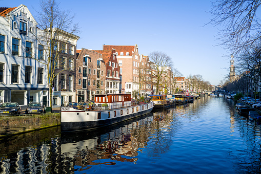 Various views of the broad, large canals of Amsterdam with reflections in the water of the unique architecture in Amsterdam, Netherlands.