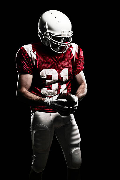 Football Player with number Football Player with number on the uniform, holding a ball. Studio Shot. american football player studio stock pictures, royalty-free photos & images