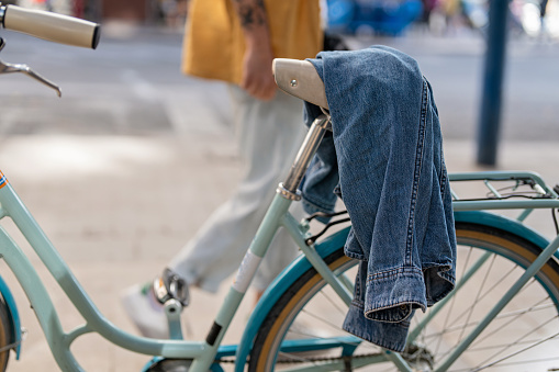 Bicycle in the city, with a denim jacket on the bicycle seat