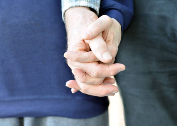 Cute smiling Vietnamese senior couple hugging outdoor on backyard patio deck