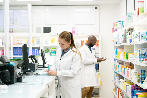 Two pharmacists working behind the counter