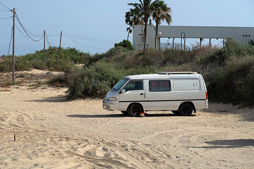 Corralejo, Fueteventura, Canary Islands, May x, 2023. Old camper vans used by surfers parked up  near Grandes beach in Dunes National park. Sunny day outdoors