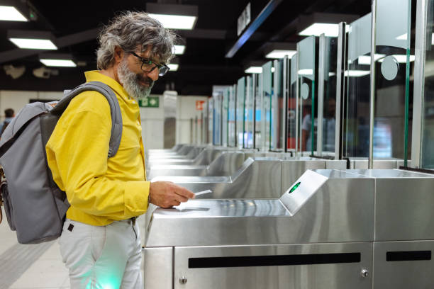 istock Senior man with backpack scanning train ticket to subway entrance gate 1491537066